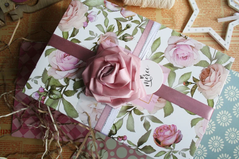 a paper box wrapped in pink and with a rose