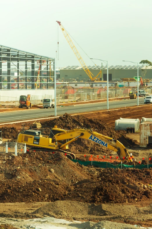 construction in a large dirt field beside a highway