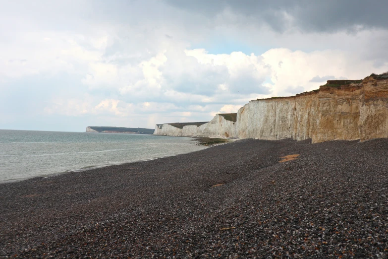 the rocky shoreline and white cliffs of a cliff by water