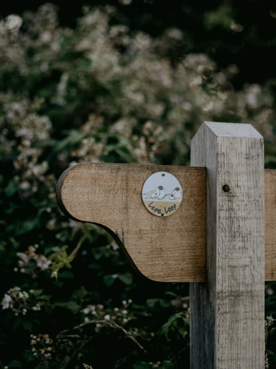 a clock mounted on a wooden post in a field