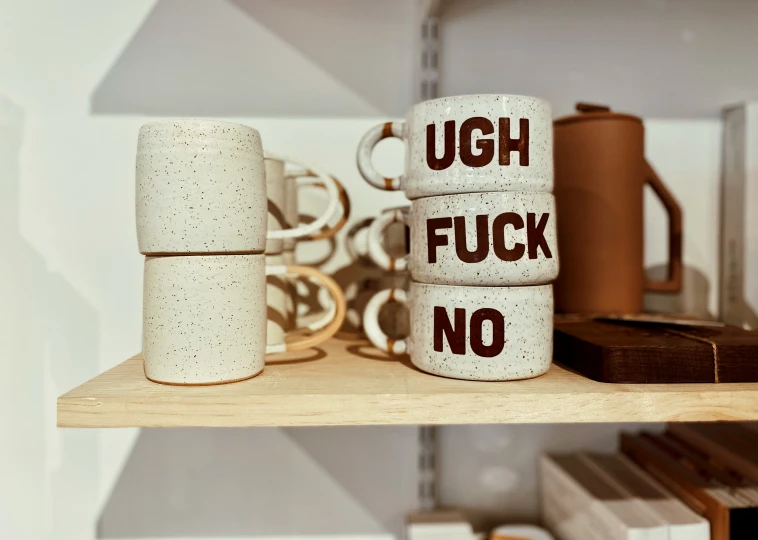 several coffee cups and ring rings on shelves