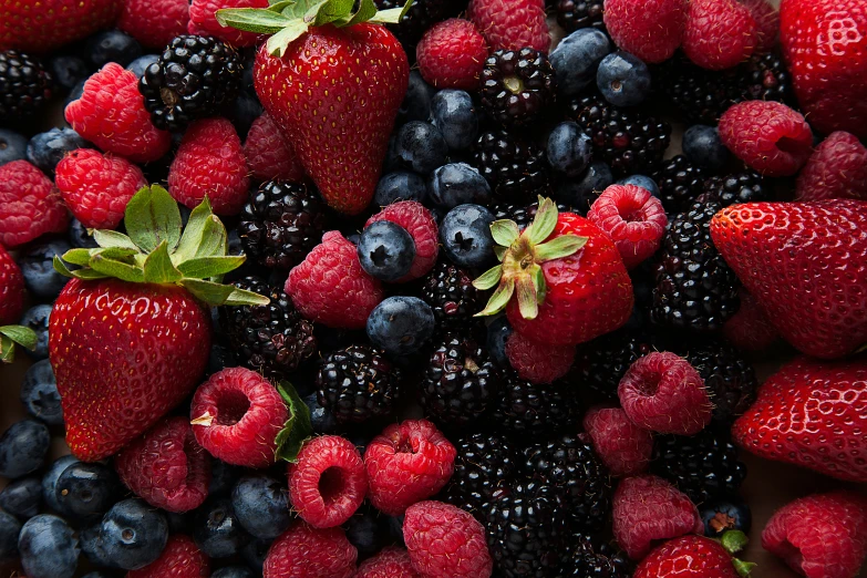 berries, raspberries and blueberries arranged in an unusual bowl