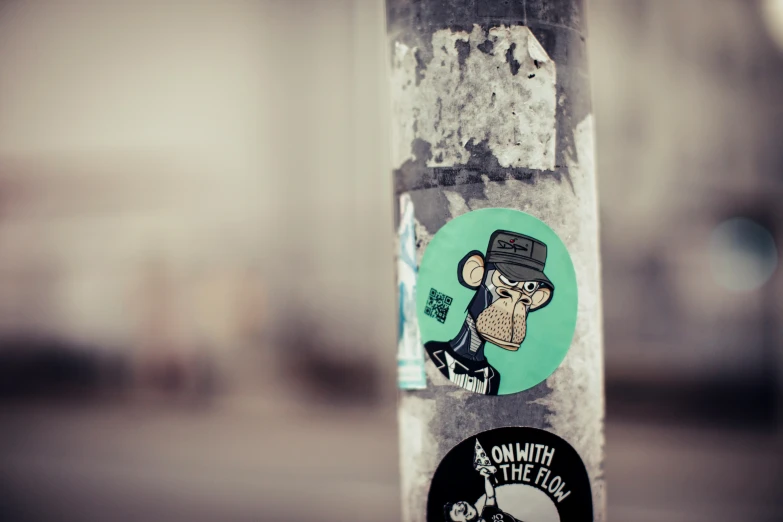 a street sticker set on a pole, with a monkey and hat