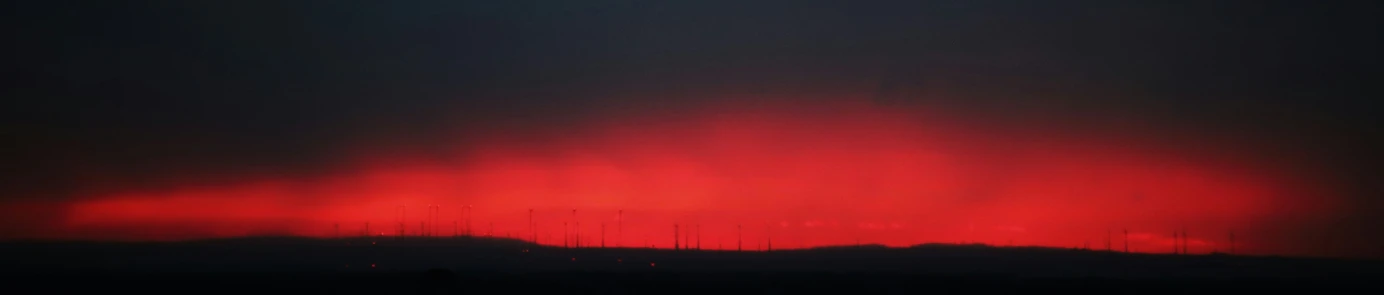 a hill with a sky of red and yellow