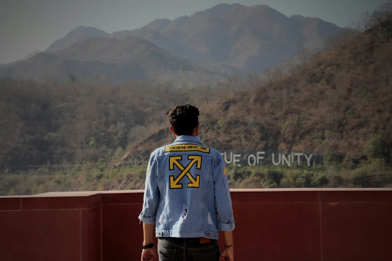 a man is standing in front of mountains and writing on the wall