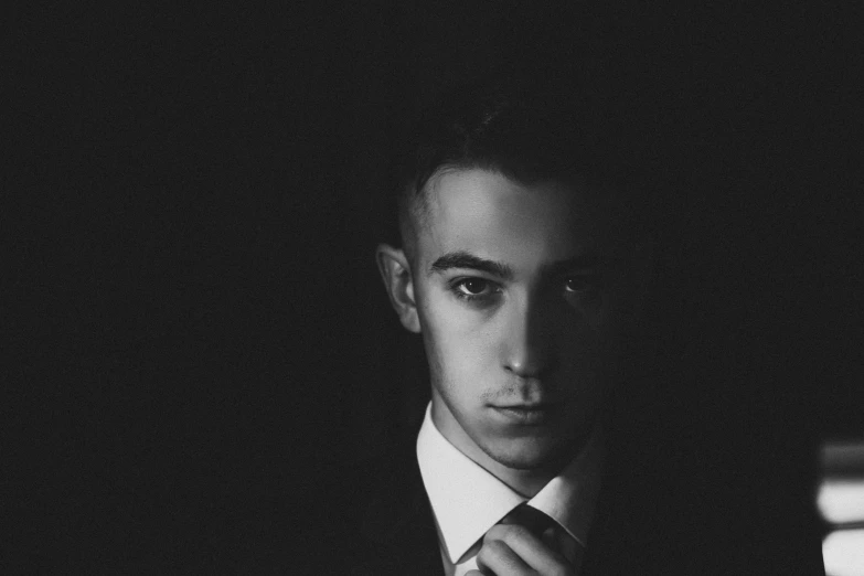 man standing in dark room looking at camera