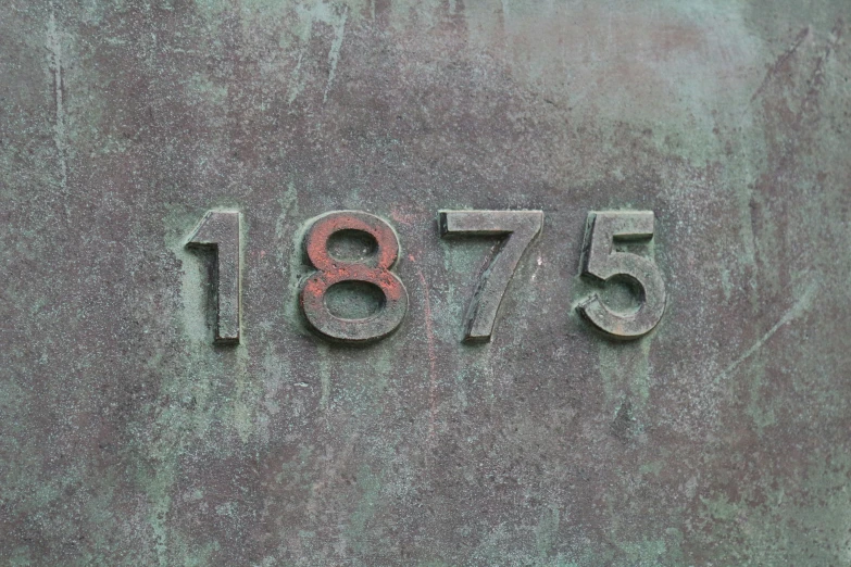 an older wall with numbers that are engraved in cement