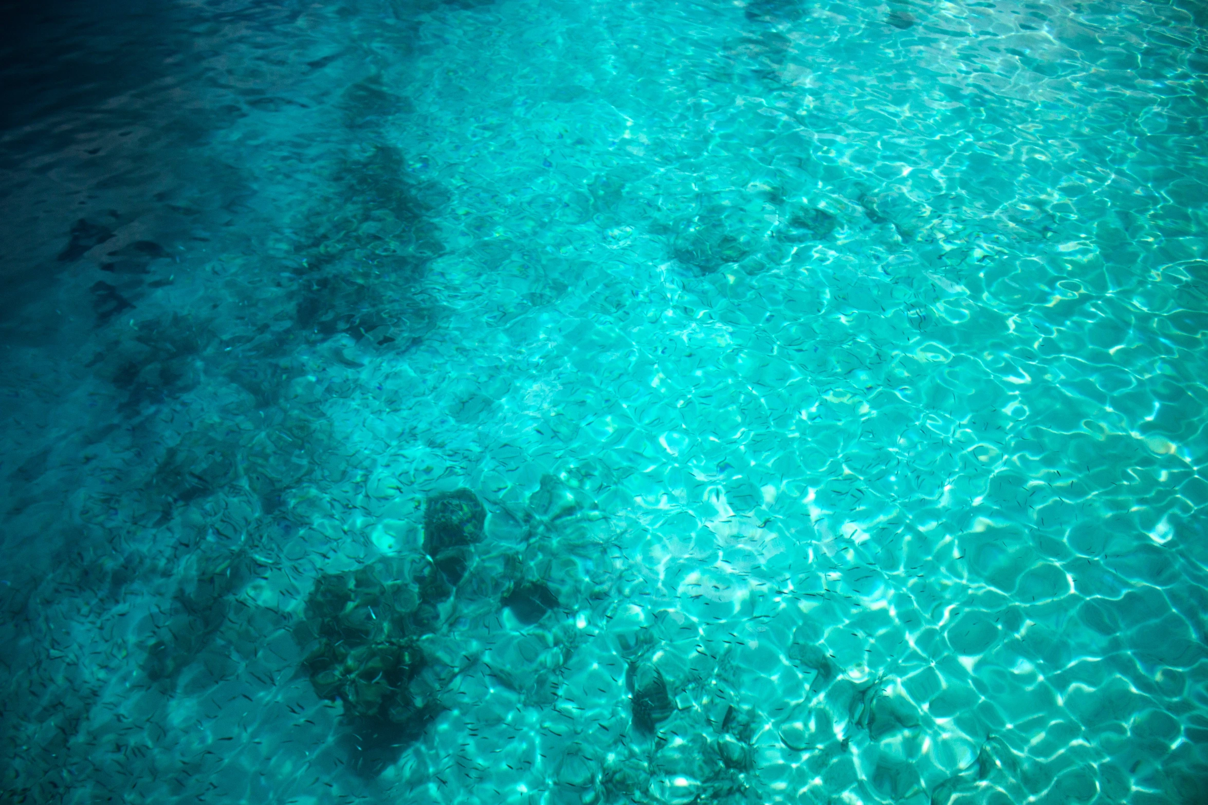 some clear blue water with rocks in it