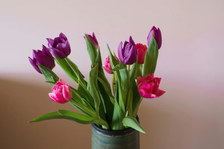 purple and pink flowers in a green vase