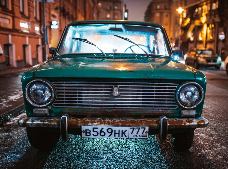 the back of an old green car with lights and mirrors on it