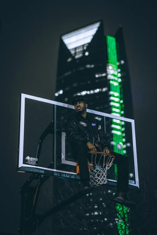 a man on the street dunking basketball in the dark