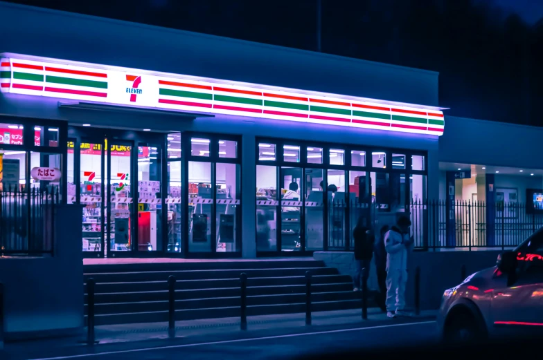 people standing outside a convenience store at night