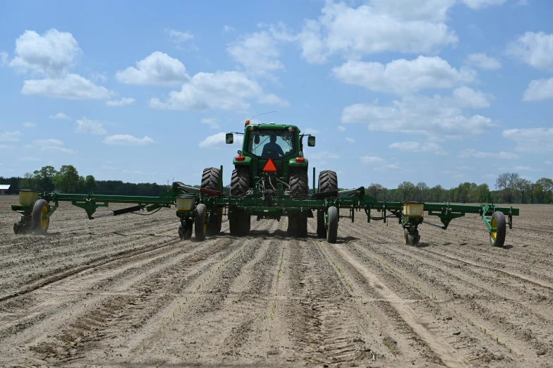 a tractor is pulling an agricultural implements trailer