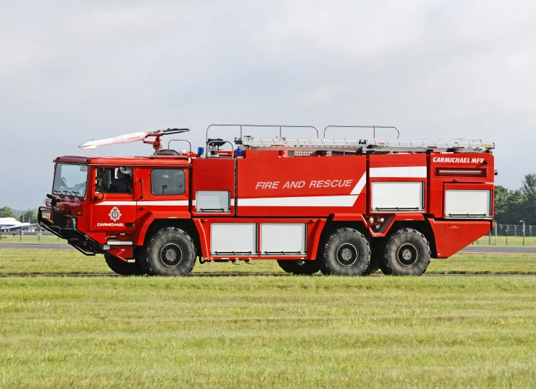 a red firetruck on the grass on a field