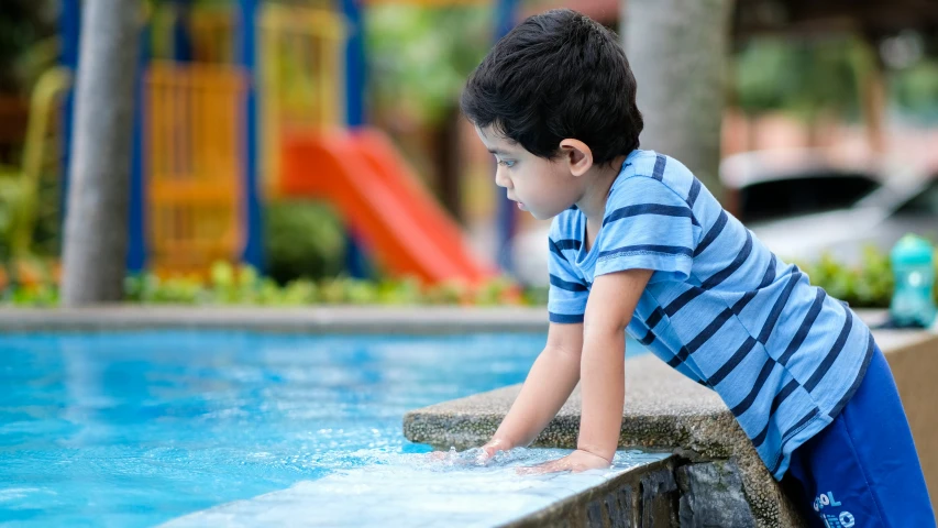 a young child playing in the water at a park