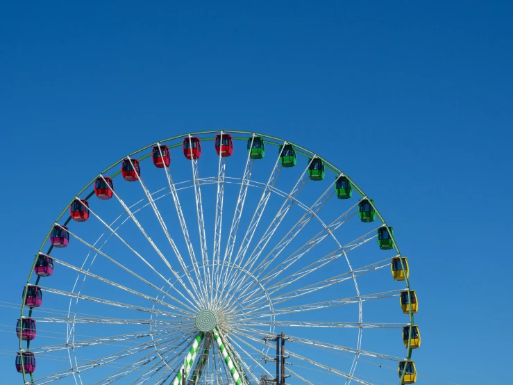 there are multiple colored lights on top of this ferris wheel