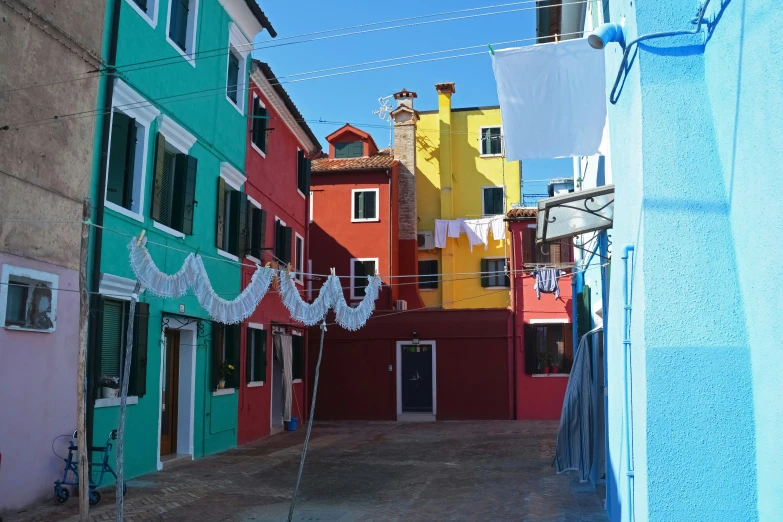 a colorful city street lined with houses and laundry line