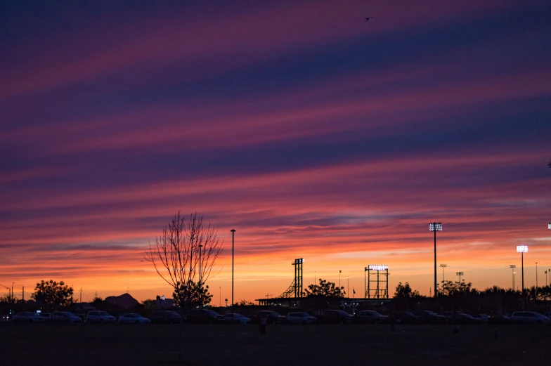 the sun sets in the sky above some parking lots