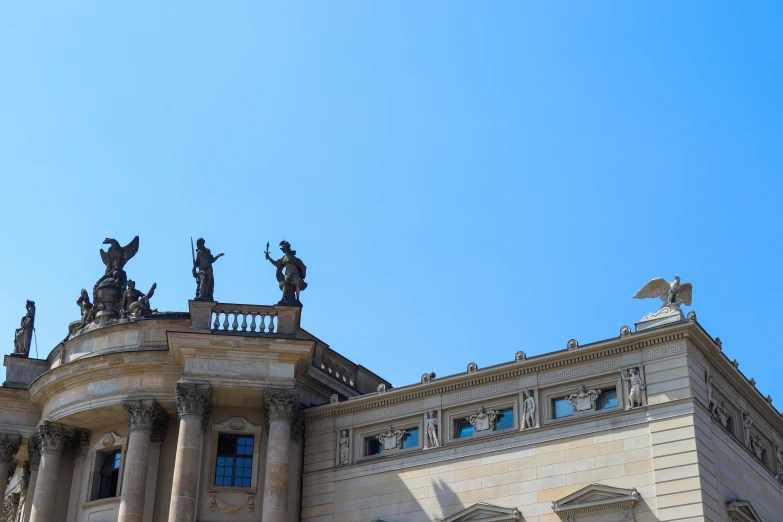 the top of a building with statues on it