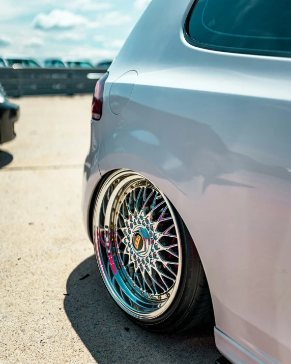 a white car with some bright colored rims on it