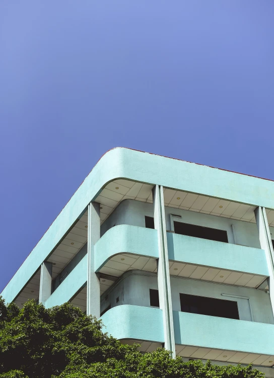 an apartment building seen from the street below, against a clear blue sky