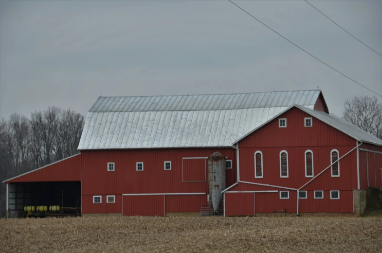 a large red barn stands out in an open field