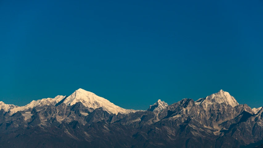 the mountains are covered in snow on a clear day