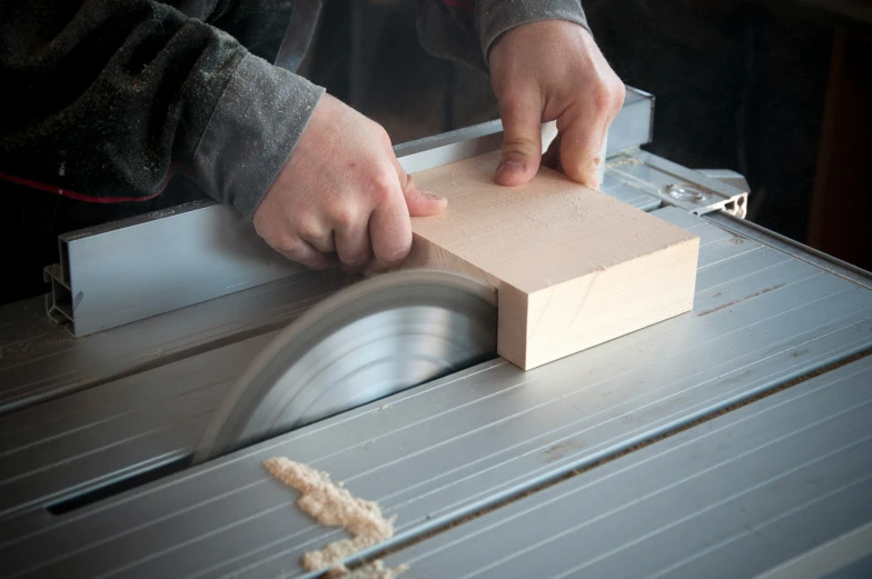 person working on wooden  with a circular saw