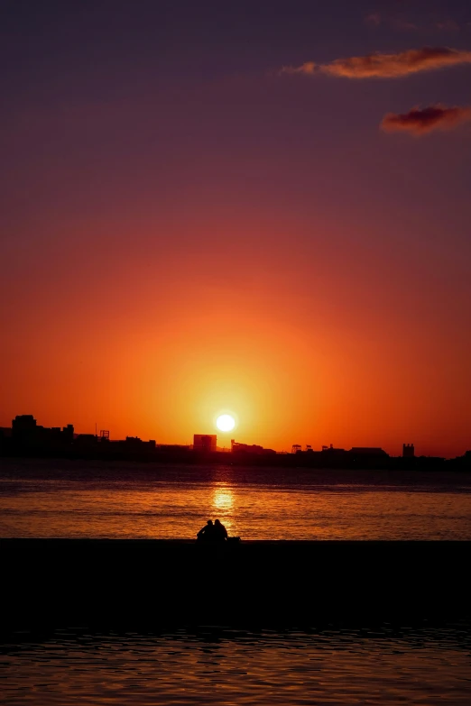 sunset with the sun rising over a body of water