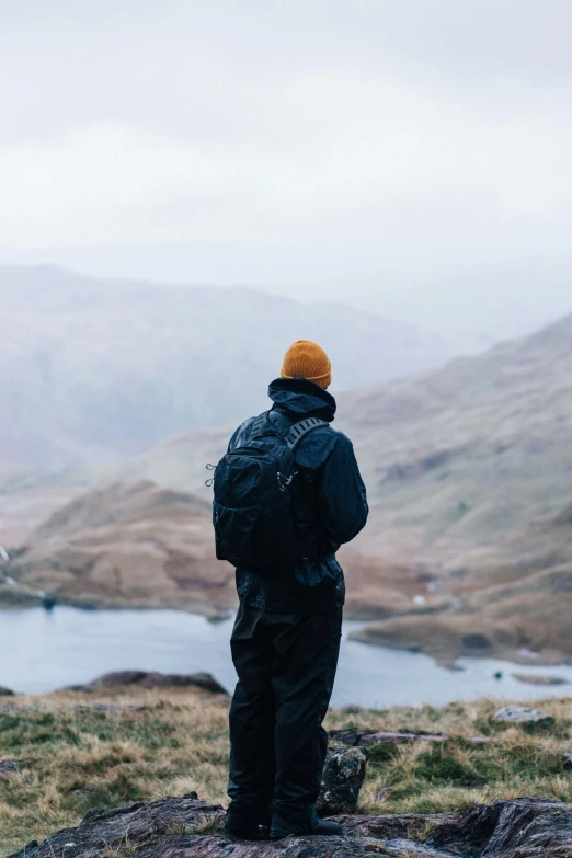 a man standing on top of a large rocky hill