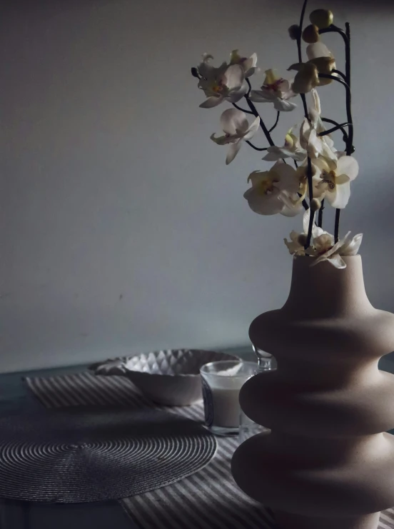 a very pretty white vase holding some pretty flowers