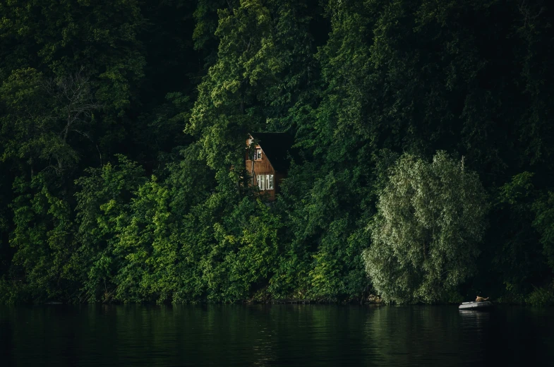 a clock is hanging above the water next to trees