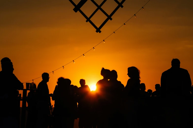 some people looking at the sunset from the roof