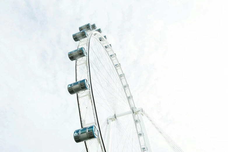 a very tall ferris wheel in a cloudy sky