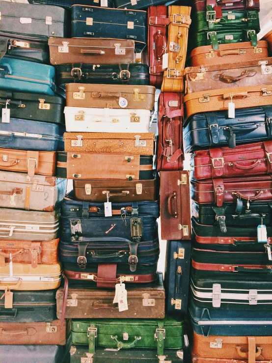 a pile of suitcases on display outside