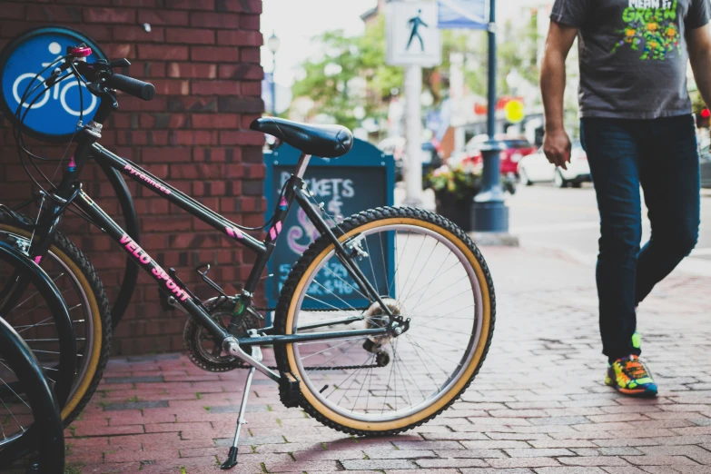 a person is walking down the sidewalk next to a bike