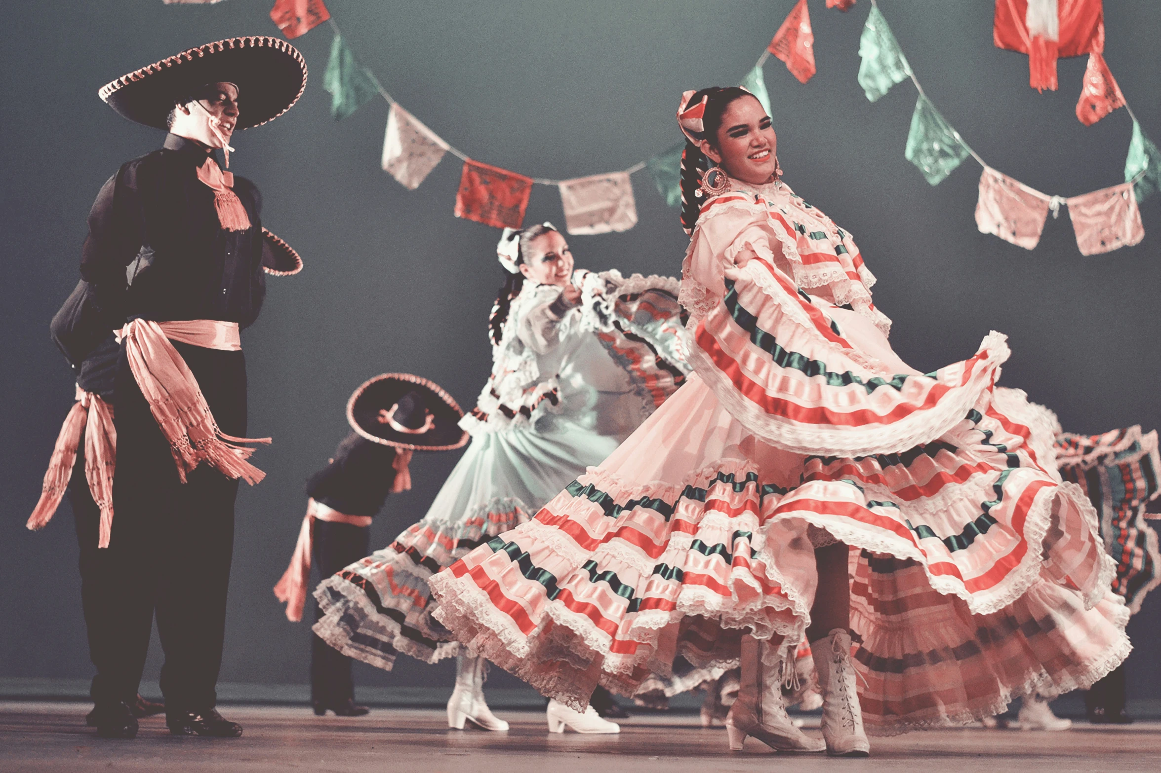 dancers perform in large mexican costumes for an audience