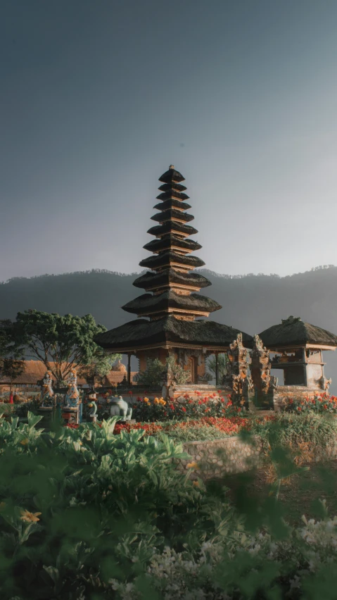 a very tall tower near a flower garden