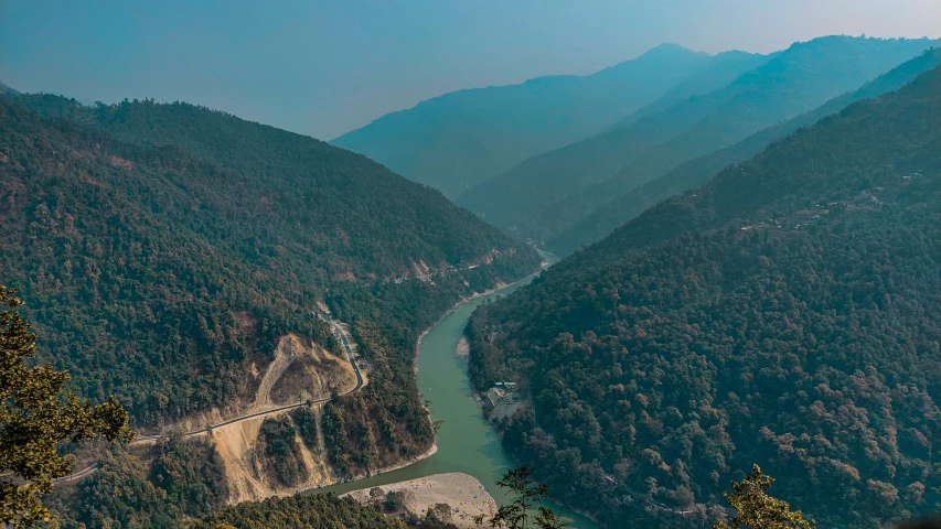 view of a green mountain river with a bridge