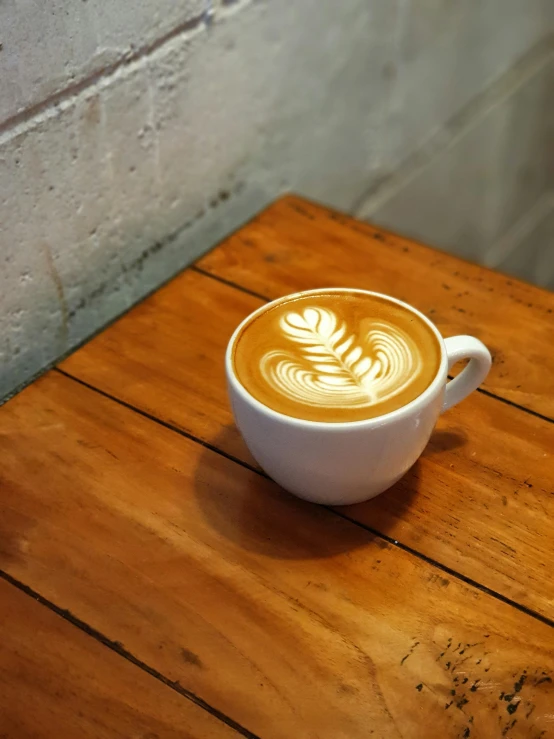 a cup filled with  chocolate on top of a wooden table