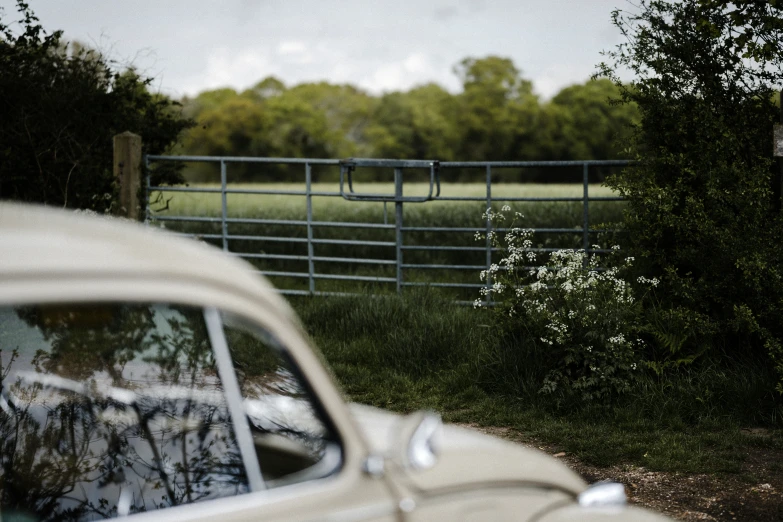 an old car parked in front of a fence