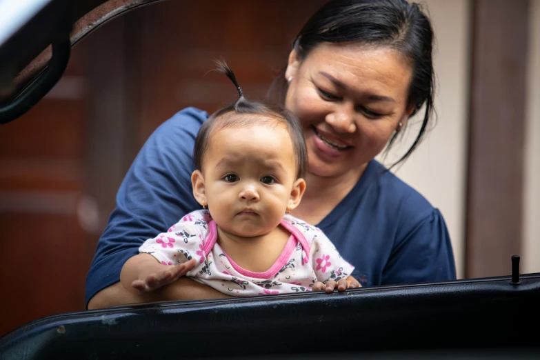 a small girl and her mother are smiling while sitting in a car