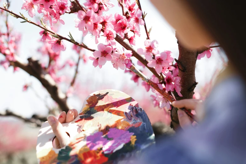 a child holding onto a paper covered piece of art