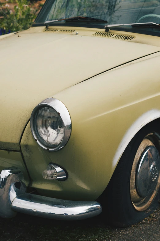 a tan car sitting next to some grass