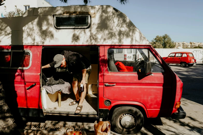 an old man and his red van with the roof up