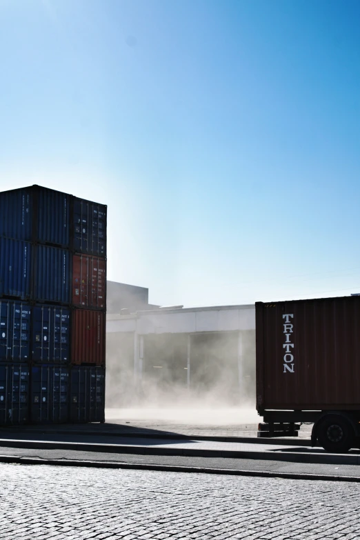 an over head s of the sand blowing behind a cargo truck