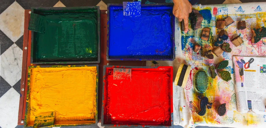 a person is holding the colorful tiles on the floor