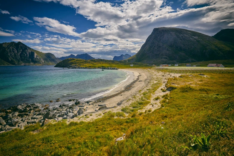 the beach is surrounded by mountains in the distance