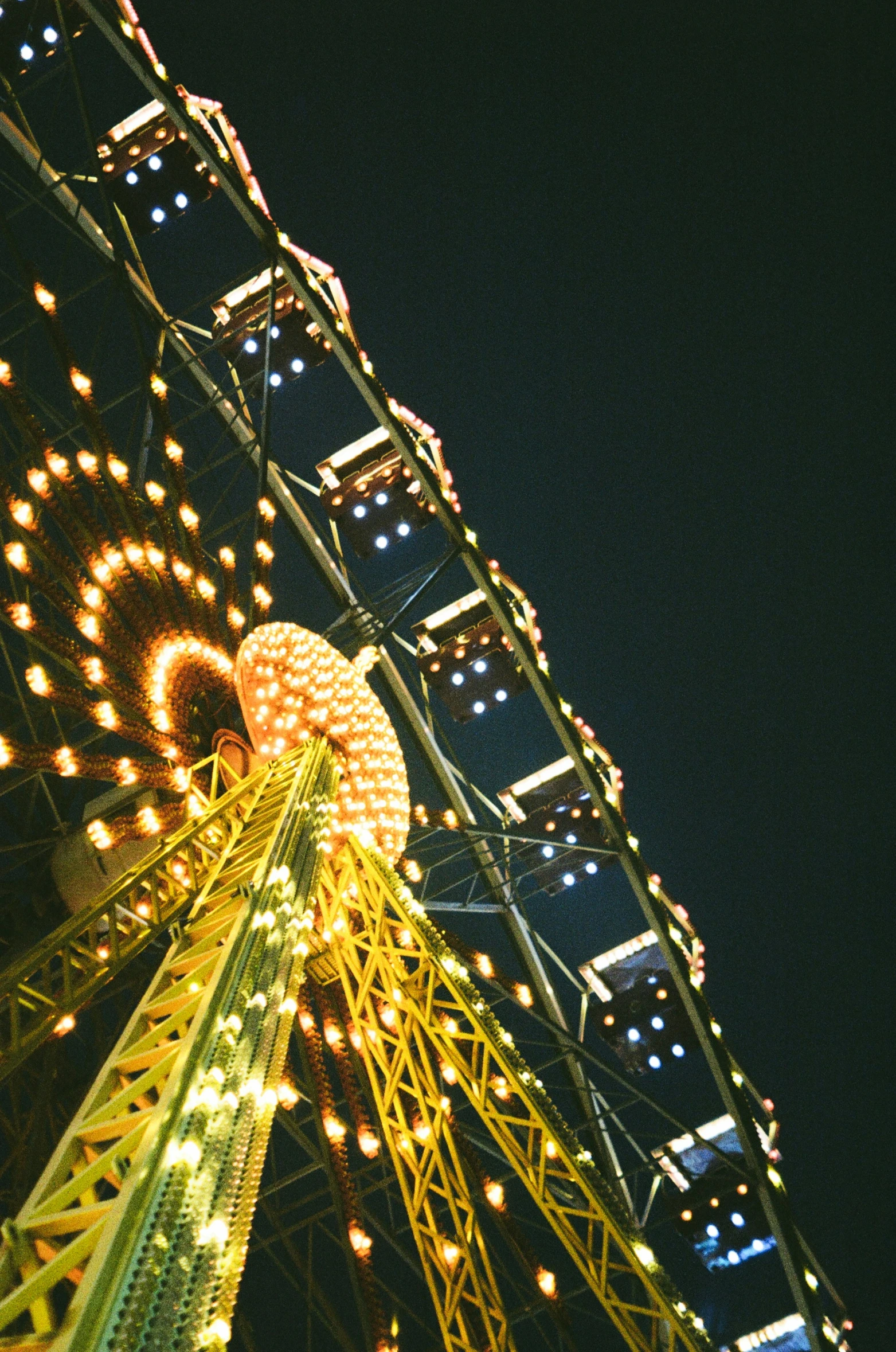 a ferris wheel sitting next to a tall building at night