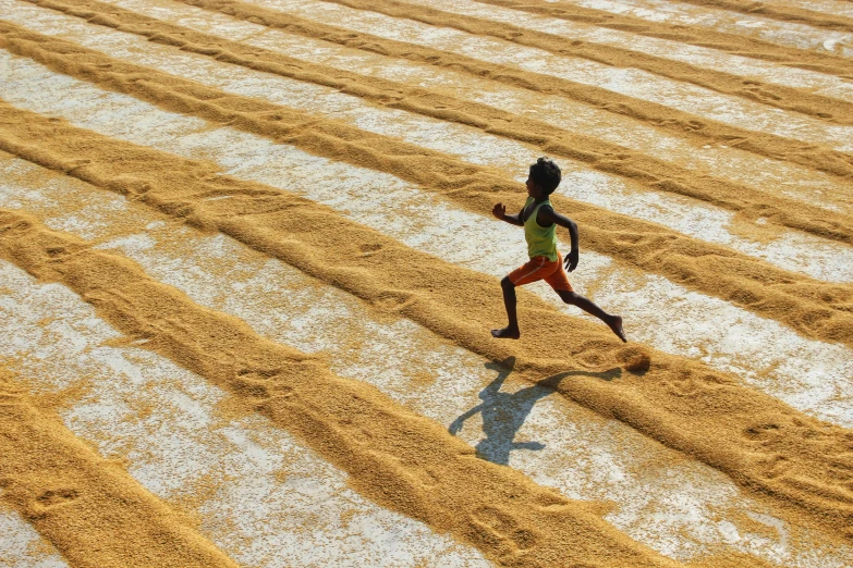 the young child is running through a yellow area